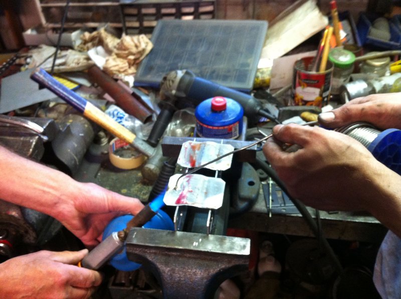 Plaatjes van zink op maat gemaakt, worden hier voorbehandeld met tin en plakspul. Gasbrander als soldeerbout.